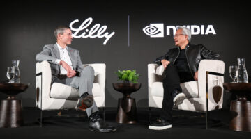 Two men on stage sitting in white chairs discussing drug discovery and GLP-1s