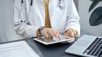 Doctor at work. Medical professional using tablet in clinic office. Medicine and health care concept.